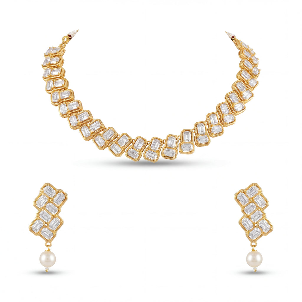 Gold necklace and earrings set with clear gemstones and pearls on a white background