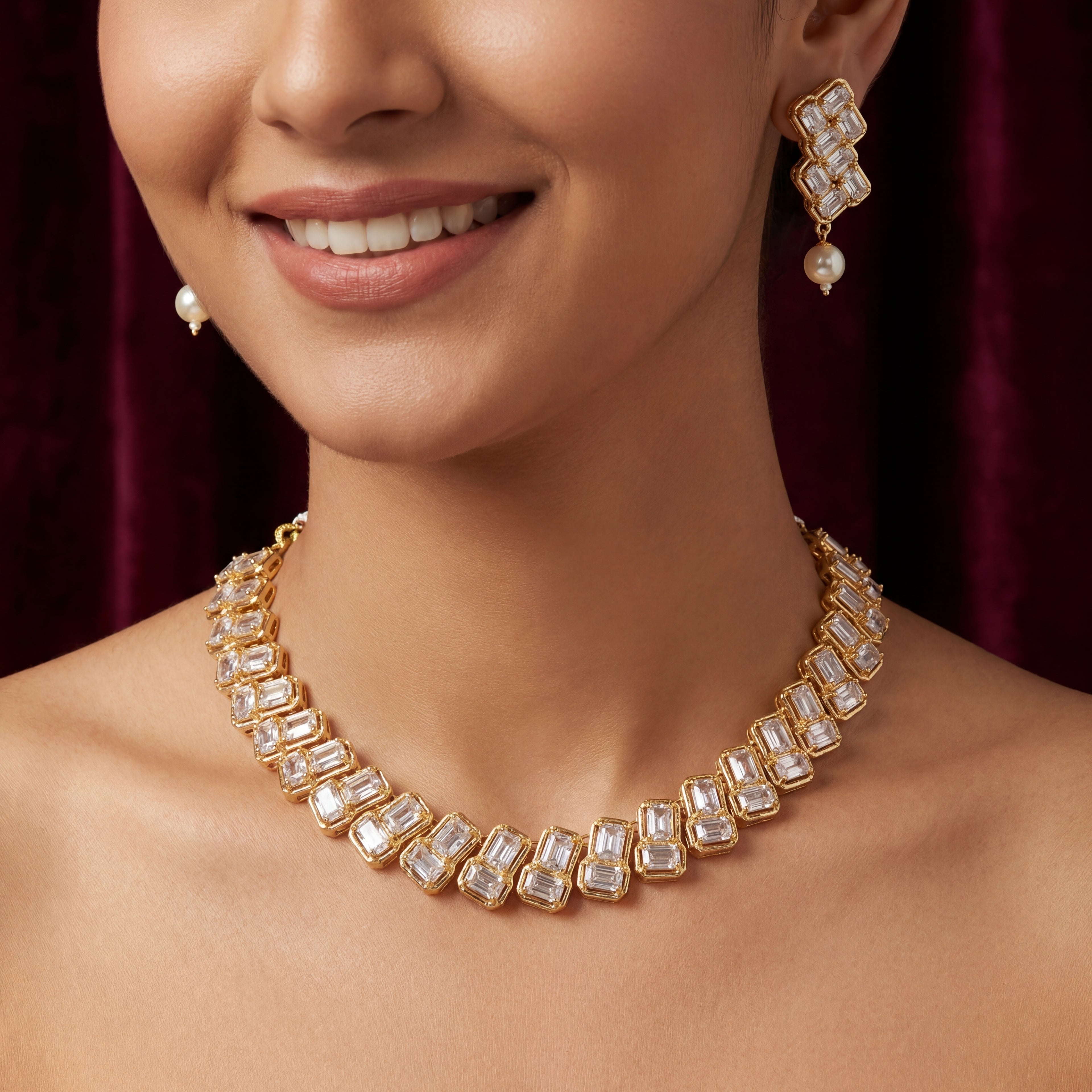 Close-up of a woman wearing a gold necklace and earrings with a blurred background